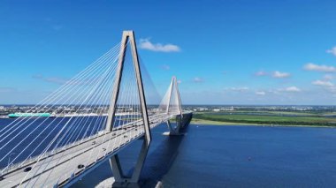 Arthur Ravenel Jr Köprüsü 'nün Charleston Güney Carolina' daki Cooper Nehri boyunca uzanan insansız hava aracı görüntüsü. Süspansiyon kabloları, mavi gökyüzü ve sakin su temiz ve modern bir ulaşım alanı yaratır..