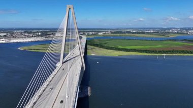 Modern bir kablonun insansız hava aracı görüntüsü sakin mavi bir nehir boyunca uzanan bir köprü vazifesi gördü. Güney Carolina 'da parlak bir yaz gününde..