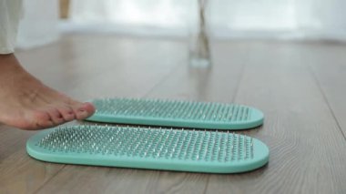 İğnelere ayak masajı. Kadın ayak iğneli masaj aletine Japon masajı yapıyor. Sağlıklı ayak konsepti.