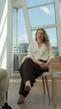 Modern bir ofiste büyük pencerelerin arkasında oturan orta yaşlı güzel bir kadının portresi. İş kadını. Toplantı. İletişim