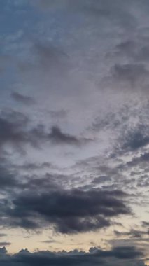 Parlayan renkleri ve çarpıcı bulut formasyonlarıyla canlı alacakaranlık sakin ve huzurlu bir hava yaratıyor. Dikey video.