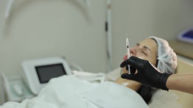 Kadın güzellik salonunda dudak büyütme için şırıngayla estetik yaptırıyor.