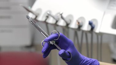 Dişçiler ellerinde diş şırıngası olan mor bir eldiven verip anestezi sıvısı fışkırtıyorlar.