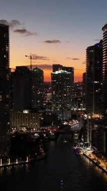 Miami 'nin alacakaranlık manzarası canlı tropikal gökyüzü ve hala alacakaranlıkta rıhtımda. Dikey video.