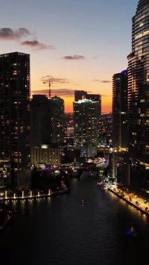 Günbatımı hava manzarası Miami 'nin sıcak akşam gökyüzünün altında parlayan gökyüzünü gözler önüne seriyor. Dikey video.