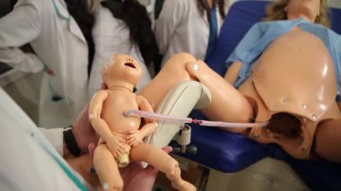 Tıp profesörü jinekoloji öğrencilerine eğitim manikini kullanarak doğum yapmayı öğretiyor.