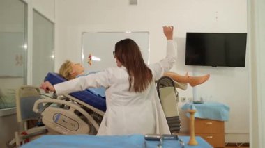 Genç bir tıp öğrencisi doğum simülatörü mankeniyle dans edip antrenman yapıyor.