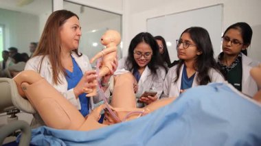 Ebelik profesörü, tıp öğrencileri için bir simülasyon mankeniyle doğum dersi veriyor.