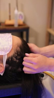 Kadın, bir güzellik salonunda rahatlama ve sağIık için kafa masajı yapıyor.