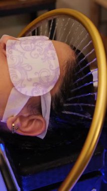 Kadın, spa salonundaki su sirkülasyon sistemiyle terapötik kafa masajı ve kafa masajı yapıyor.