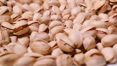 Beyaz bir zemin üzerinde dönen tuzlanmış şam fıstığının yakın görüntüsü