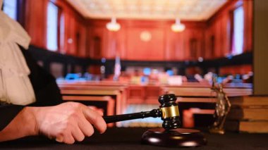 Yargıçlar mahkeme salonunda kararı duyurmak için tahta bir tokmağa vuruyor.