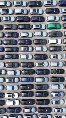 Kalabalık bir otoparkta düzgünce park edilmiş birçok aracın insansız hava aracı görüntüleri.