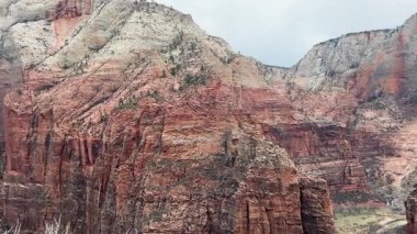 Görkemli hava perspektifi, Siyon Kanyonu 'nun çarpıcı kırmızı kaya oluşumları üzerinde geriye doğru uçuyor.