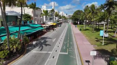 Okyanus manzarası, turistler yürüyor ve güneşli bir günde araba sürüyor.