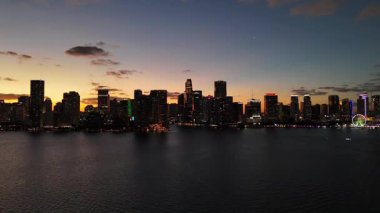 Gün batımında Biscayne Körfezi 'nin sakin sularına yansıyan parlak Miami şehir merkezi silueti.