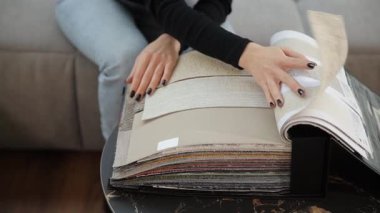 Profesyonel iç mimar mobilya döşeme kataloğundan tekstil örnekleri seçiyor