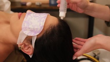 Kadın güzellik salonunda ya da kaplıcada kafa derisi ve saç bakımı tedavisi görüyor.