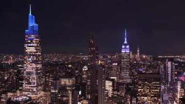 Manhattan şehir merkezinin panoramik manzarası New York 'ta gece parlayan gökdelenleri ile gökyüzü