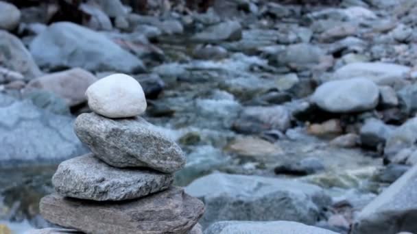 Stone cairn bredvid en flod — Stockvideo