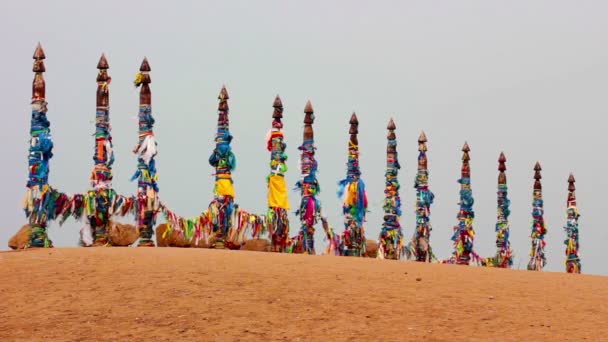 Serge. Postes sagrados con cintas de colores en la isla Olkhon. Burkhan, Lago Baikal — Vídeos de Stock