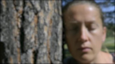 Ağacın yanındaki kız ağır çekimde. Bulanıklığa yakınlaştır