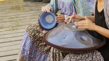 Kızlar perküsyon enstrümanları çalar. Bir djembe ve tank davulunda müzik çalmak