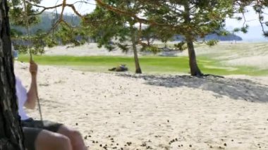 Plaj salıncakta dinleniyor. Kız salıncakta sallanıyor. Yavaş çekim