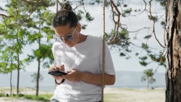 Девушка проводит время в отпуске с мобильными устройствами — стоковое видео