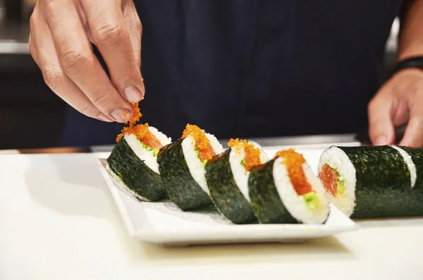 스시 롤 tobiko (로우)를 파 종 하는 요리사 — 스톡 사진