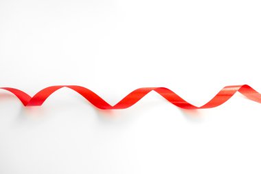 Beyaz arkaplanda yumuşak gölgesi olan parlak kırmızı kurdele