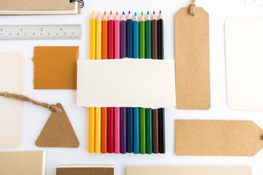 Çeşitli kağıt, karton, etiket, kart, kitap ve renkli kalemlerin toplanması.