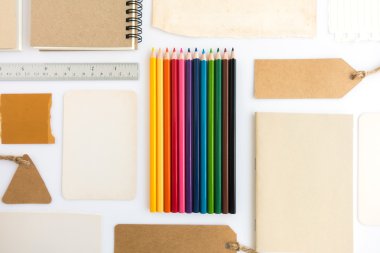 Çeşitli kağıt, karton, etiket, kart, kitap ve renkli kalemlerin toplanması.