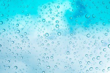 Su arka plan damla. Su cam pencere üzerinde üzerinde mavi gökyüzü düşüyor.