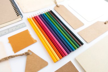 Çeşitli kağıt, karton, etiket, kart, kitap ve renkli kalemlerin toplanması.