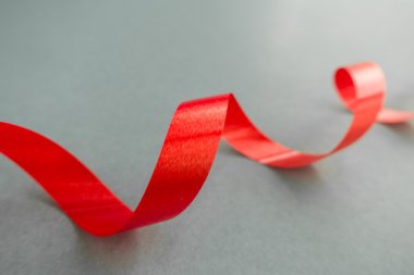 Gri arkaplanda yumuşak gölgesi olan parlak kırmızı kurdele