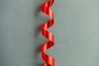 Gri arkaplanda yumuşak gölgesi olan parlak kırmızı kurdele