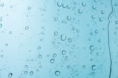 Su arka plan damla. Su cam pencere üzerinde üzerinde mavi gökyüzü düşüyor.