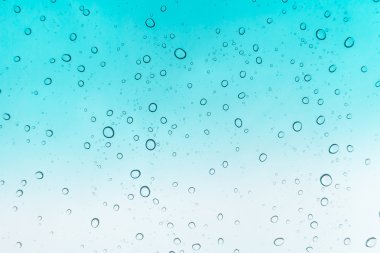 Su arka plan damla. Su cam pencere üzerinde üzerinde mavi gökyüzü düşüyor.