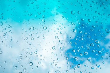 Su arka plan damla. Su cam pencere üzerinde üzerinde mavi gökyüzü düşüyor.