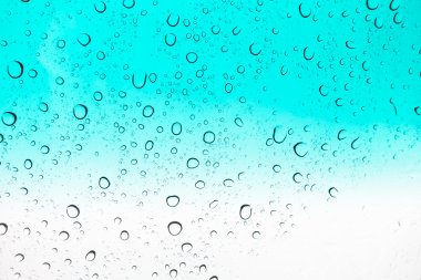 Su arka plan damla. Su cam pencere üzerinde üzerinde mavi gökyüzü düşüyor..