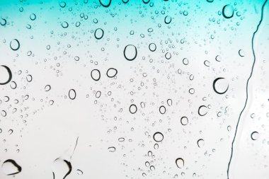 Su arka plan damla. Su cam pencere üzerinde üzerinde mavi gökyüzü düşüyor..