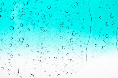 Su arka plan damla. Su cam pencere üzerinde üzerinde mavi gökyüzü düşüyor..