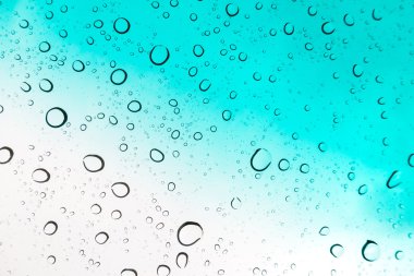 Su arka plan damla. Su cam pencere üzerinde üzerinde mavi gökyüzü düşüyor..