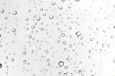 Su arka plan damla. Su cam pencere üzerinde üzerinde mavi gökyüzü düşüyor..