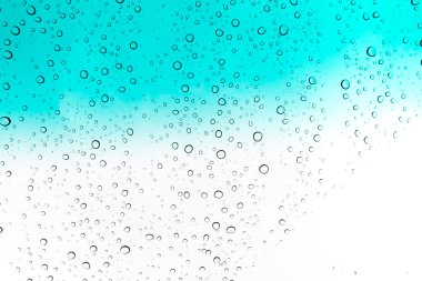 Su arka plan damla. Su cam pencere üzerinde üzerinde mavi gökyüzü düşüyor..