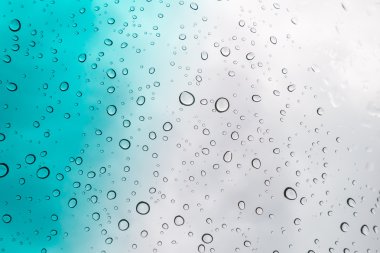 Su arka plan damla. Su cam pencere üzerinde üzerinde mavi gökyüzü düşüyor..