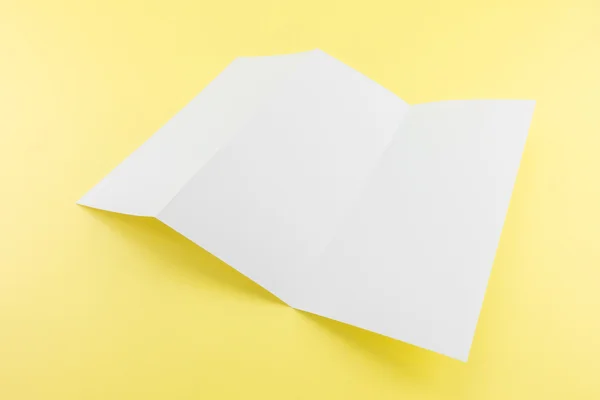 空白の柔らかい影と黄色の背景に白いテンプレートの紙を三つ折り あなたのデザインの準備 — ストック写真