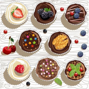 Muffinler, kekler ve ahşap dextur üzerinde farklı türde peri pastaları, böğürtlenler, yabanmersinleri, çilekler, kızılcıklar ve ahududular