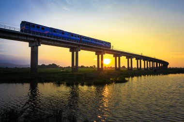 Bir tren Köprüsü günbatımı zamanı geçiyor